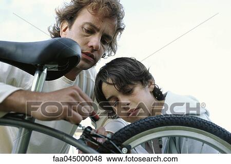 Father and son repairing bicycle together View Large Photo Image Stock Photo - Father and son repairing bicycle together. Fotosearch