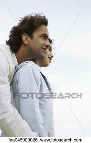 Father standing behind young daughter, looking over shoulder, both admiring view View Large Photo Image Stock Photograph - Father standing behind young daughter, looking over shoulder, both admiring view. Fotosearch