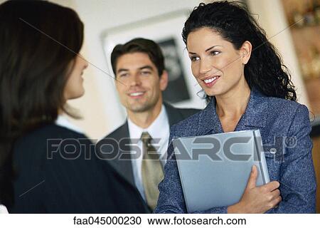 Stock Image - Female associate meeting with colleagues. Fotosearch