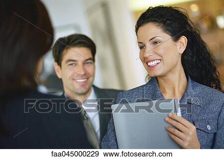Stock Photo - Female associate meeting with colleagues. Fotosearch