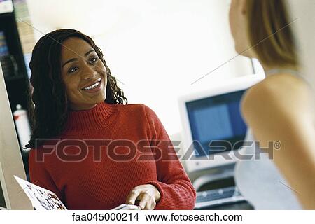 Female colleagues talking in office View Large Photo Image Picture - Female colleagues talking in office. Fotosearch