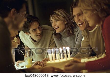 Friends laughing, smiling at each other, gathered together around birthday cake View Large Photo Image Stock Image - Friends laughing, smiling at each other, gathered together around birthday cake. Fotosearch