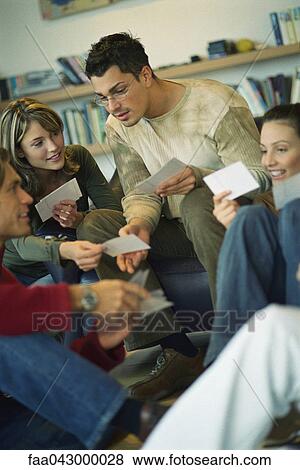 Friends looking at each other's photo collection View Large Photo Image Stock Photo - Friends looking at each other's photo collection. Fotosearch