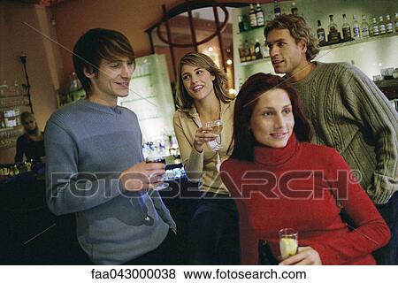 Friends talking, having drinks together at wine bar View Large Photo Image Stock Photo - Friends talking, having drinks together at wine bar. Fotosearch