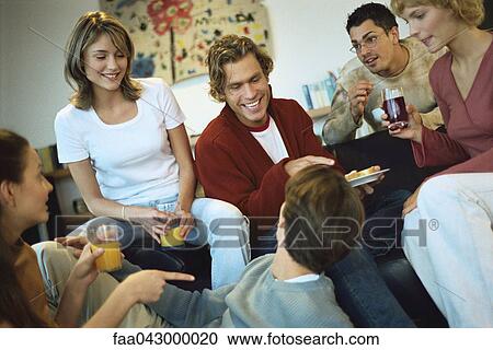 Stock Image - Gathering of friends at house party. Fotosearch