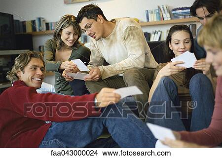 Gathering of friends looking at photos View Large Photo Image Picture - Gathering of friends looking at photos. Fotosearch