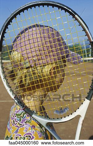 Girl holding tennis racket looking at tennis court View Large Photo Image Stock Image - Girl holding tennis racket looking at tennis court. Fotosearch