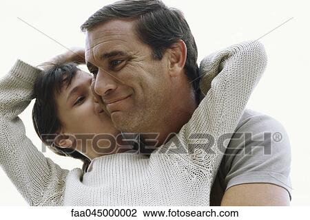 Stock Image - Girl kissing her father on cheek. Fotosearch