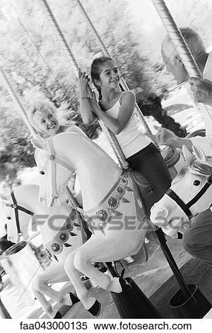 Girl riding carousel with her grandparents View Large Photo Image Stock Photography - Girl riding carousel with her grandparents. Fotosearch