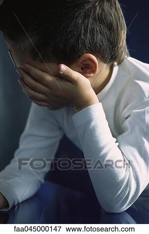 Little boy holding head, upset, covering face View Large Photo Image Stock Photo - Little boy holding head, upset, covering face. Fotosearch