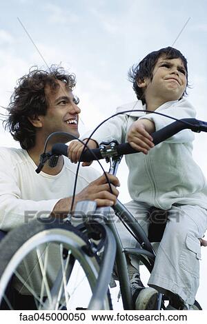 Little boy on bicycle stubbornly looking away, father kneeling at side smiling reassuringly View Large Photo Image Stock Image - Little boy on bicycle stubbornly looking away, father kneeling at side smiling reassuringly. Fotosearch