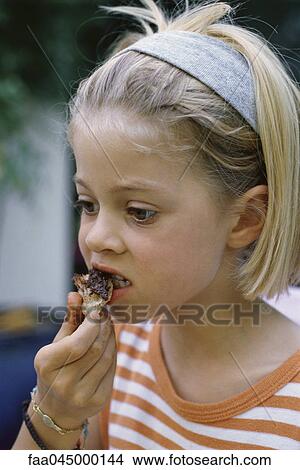 Picture - Little girl eating snack. Fotosearch