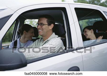 Stock Photo - Man driving family on road trip. Fotosearch