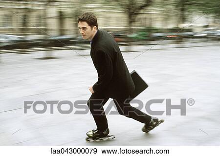 Man in business attire inline skating carrying briefcase in city square View Large Photo Image Stock Photo - Man in business attire inline skating carrying briefcase in city square. Fotosearch