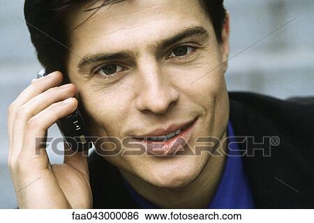 Stock Photograph - Man phoning using cell phone, portrait. Fotosearch