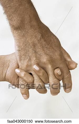 Stock Image - Man's hand holding woman's hand. Fotosearch