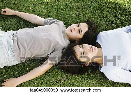 Mother and son reclining together in grass, viewed from directly above View Large Photo Image Stock Photo - Mother and son reclining together in grass, viewed from directly above. Fotosearch