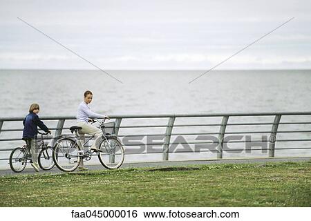 Mother and son riding bicycles at seaside park View Large Photo Image Stock Photograph - Mother and son riding bicycles at seaside park. Fotosearch