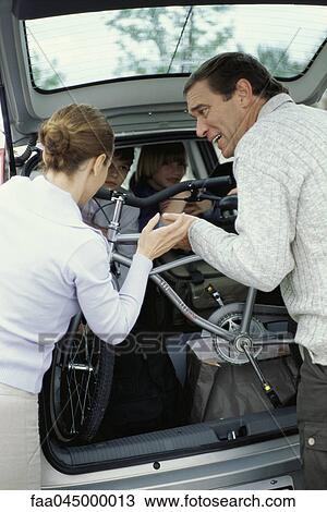Parents struggling to pack car in preparation for road trip View Large Photo Image Stock Image - Parents struggling to pack car in preparation for road trip. Fotosearch