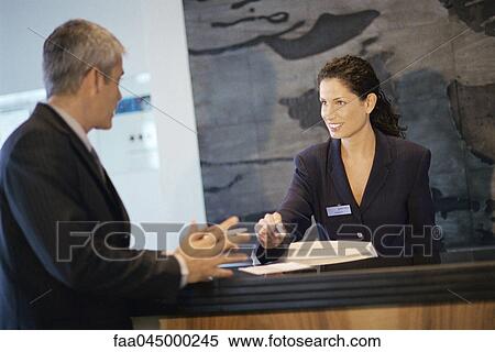 Stock Photography - Receptionist talking with businessman. Fotosearch