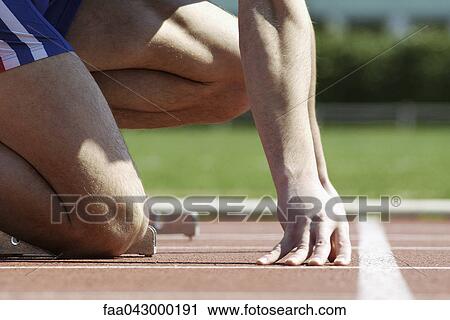 Runner crouching at starting line, cropped View Large Photo Image Stock Image - Runner crouching at starting line, cropped. Fotosearch