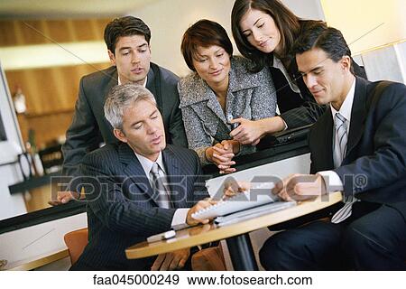 Team of associates collaborating in office View Large Photo Image Stock Photo - Team of associates collaborating in office. Fotosearch