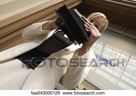 Well dressed woman looking through purse, low angle view View Large Photo Image Stock Photo - Well dressed woman looking through purse, low angle view. Fotosearch