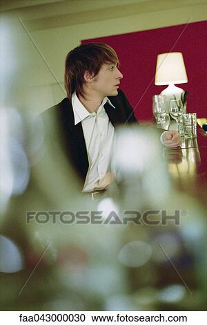 Stock Image - Well dressed young man at bar. Fotosearch
