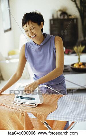 Woman doing ironing and laughing View Large Photo Image Stock Photograph - Woman doing ironing and laughing. Fotosearch