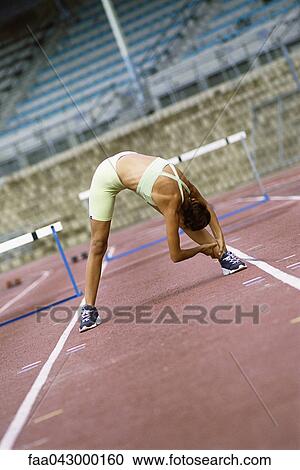 Woman doing stretches on running track View Large Photo Image Stock Image - Woman doing stretches on running track. Fotosearch