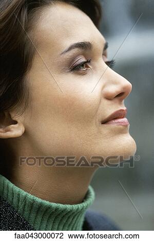Stock Image - Woman looking away with eye on future aspirations. Fotosearch