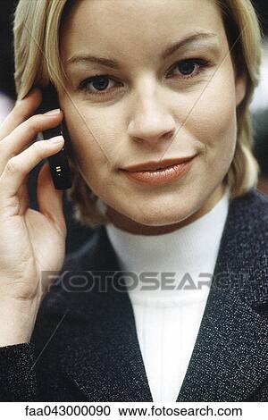Stock Image - Woman phoning using cell phone looking with optimistic determination at camera, portrait. Fotosearch