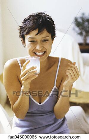 Woman smiling, holding glass of milk View Large Photo Image Stock Photography - Woman smiling, holding glass of milk. Fotosearch