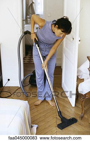 Stock Image - Woman vacuuming. Fotosearch