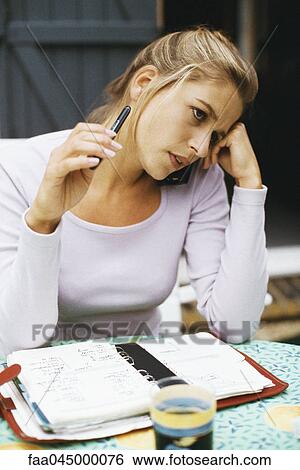 Stock Photograph - Woman with open agenda, contemplatively looking away. Fotosearch