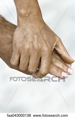 Stock Photo - Woman's hand holding man's hand, close-up. Fotosearch