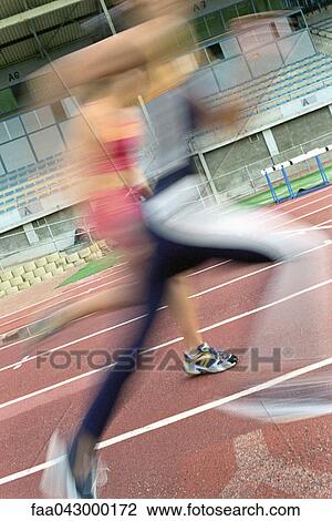 Stock Image - Women running on track, blurred. Fotosearch