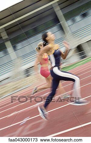Stock Image - Women running on track, blurred. Fotosearch