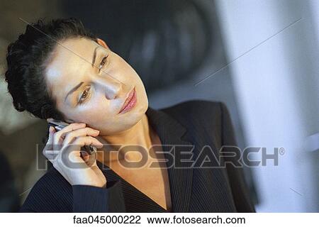 Young businesswoman using cell phone, looking away dreamily View Large Photo Image Stock Image - Young businesswoman using cell phone, looking away dreamily. Fotosearch