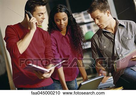 Young colleagues collaborating in casual office environment View Large Photo Image Stock Image - Young colleagues collaborating in casual office environment. Fotosearch