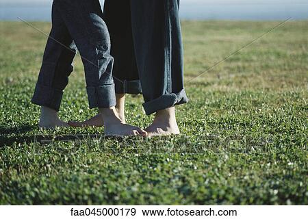 Young couple standing barefoot in field, low section View Large Photo Image Stock Photo - Young couple standing barefoot in field, low section. Fotosearch
