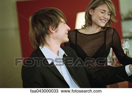 Young couple together at bar, woman with eyes closed laughing View Large Photo Image Stock Image - Young couple together at bar, woman with eyes closed laughing. Fotosearch