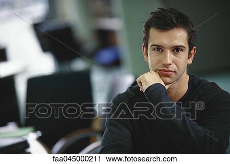 Young professional man holding chin, portrait View Large Photo Image Stock Image - Young professional man holding chin, portrait. Fotosearch