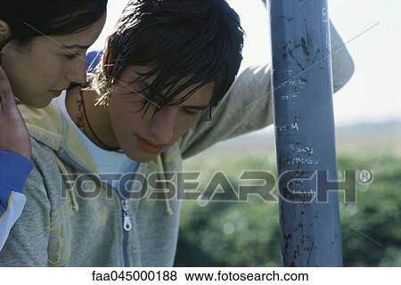 Stock Photo - Young woman comforting boyfriend. Fotosearch