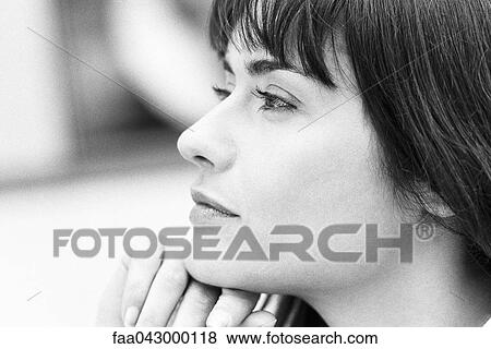 Young woman with hand under chin looking away, portrait View Large Photo Image Stock Photo - Young woman with hand under chin looking away, portrait. Fotosearch