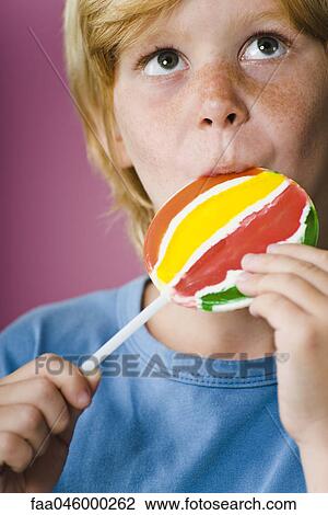 Boy eating lollipop View Large Photo Image Stock Image - Boy eating lollipop. Fotosearch