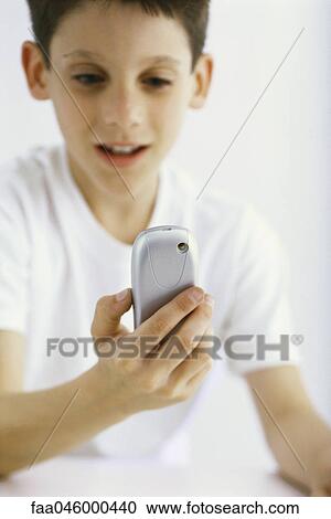 Boy looking at cell phone View Large Photo Image Stock Image - Boy looking at cell phone. Fotosearch