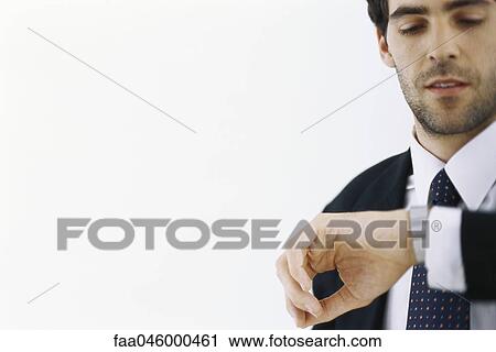 Businessman checking time, looking at watch View Large Photo Image Stock Image - Businessman checking time, looking at watch. Fotosearch