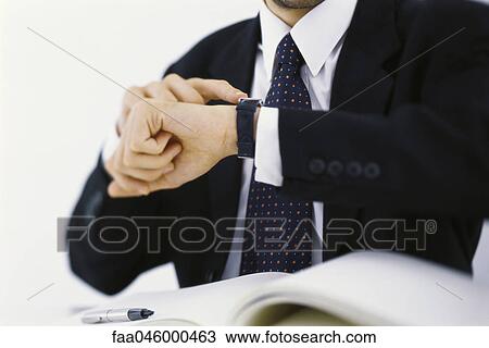 Businessman checking time on wristwatch, cropped View Large Photo Image Stock Image - Businessman checking time on wristwatch, cropped. Fotosearch