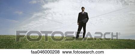 Businessman in grassy field with hand in pocket View Large Photo Image Stock Photo - Businessman in grassy field with hand in pocket. Fotosearch